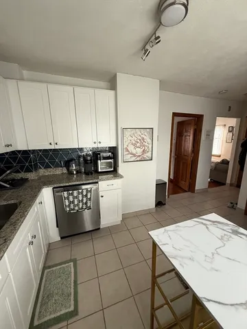 a kitchen with stainless steel appliances granite countertop a stove a sink and a white cabinets