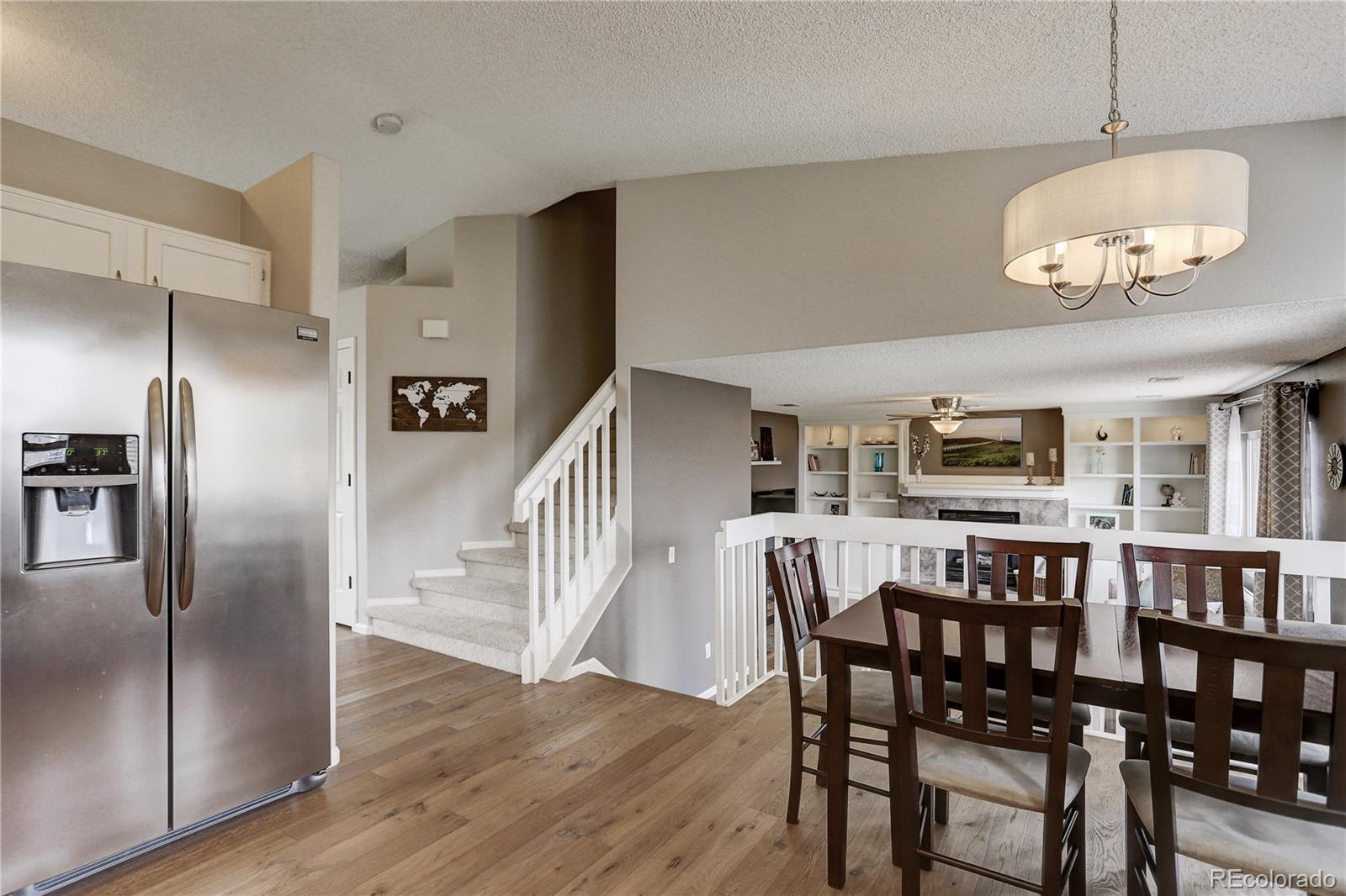10626 Hyacinth Court Highlands Ranch, CO 80129 - Photo 12 of 38 a view of a dining room with furniture a chandelier and wooden floor