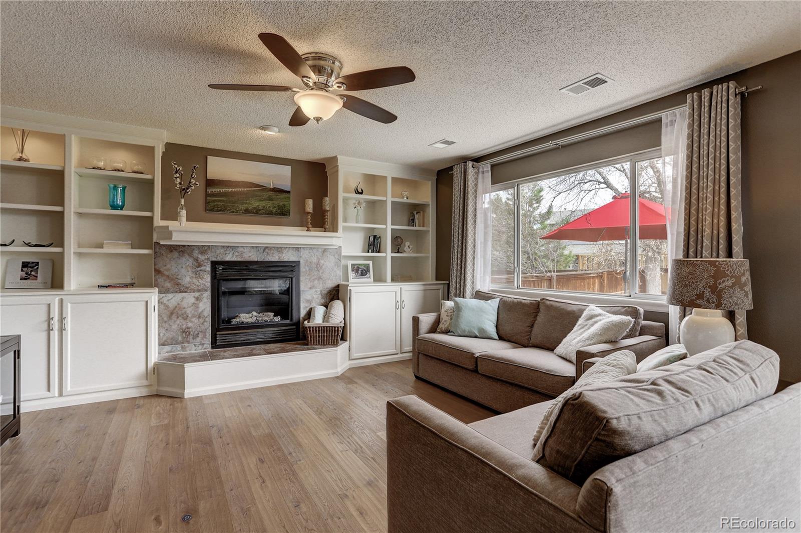 10626 Hyacinth Court Highlands Ranch, CO 80129 - Photo 14 of 38 a living room with furniture a fireplace and a flat screen tv