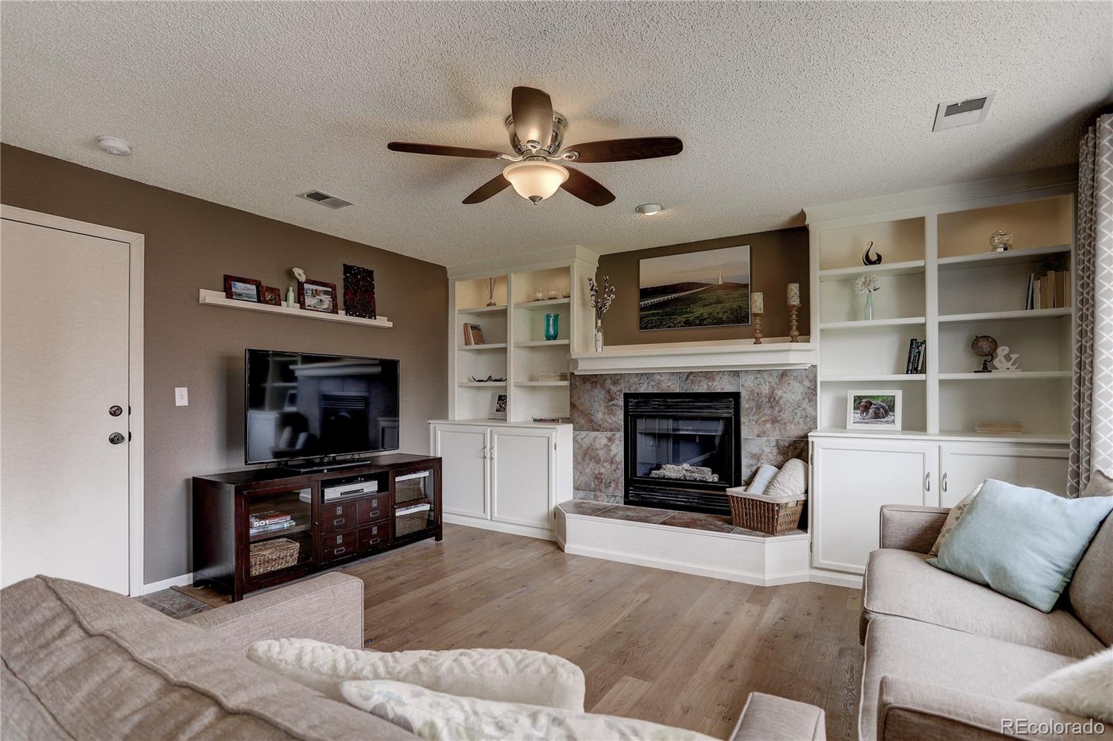 10626 Hyacinth Court Highlands Ranch, CO 80129 - Photo 15 of 38 a living room with furniture a flat screen tv and a fireplace