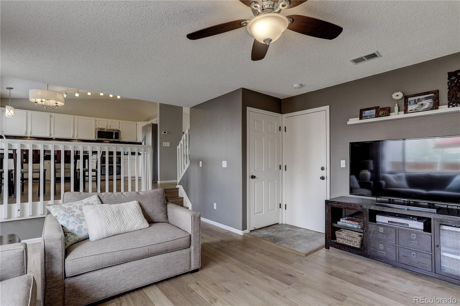 10626 Hyacinth Court Highlands Ranch, CO 80129 - Photo 17 of 38 a living room with furniture and a flat screen tv