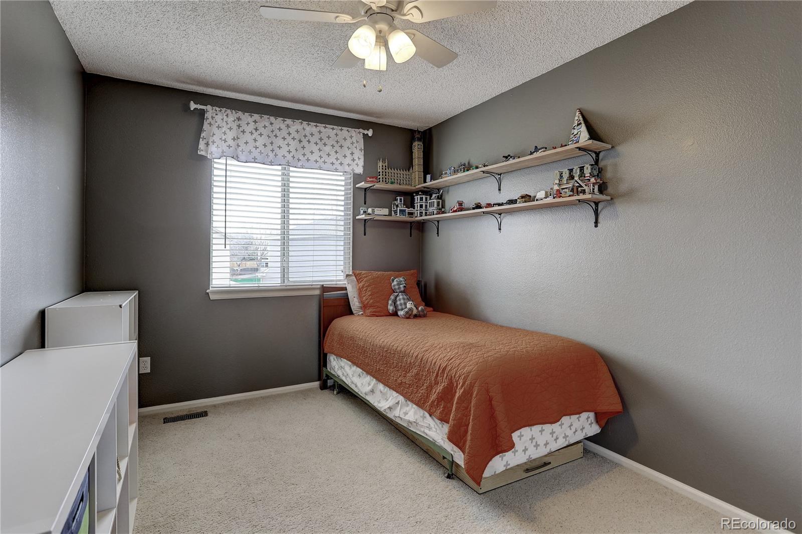 10626 Hyacinth Court Highlands Ranch, CO 80129 - Photo 19 of 38 a bedroom with a bed and a chandelier