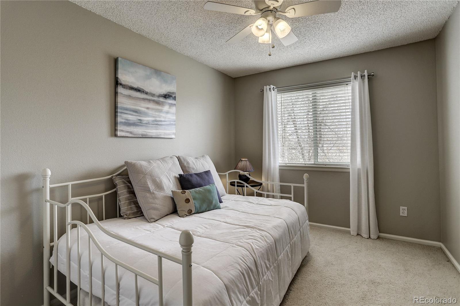 10626 Hyacinth Court Highlands Ranch, CO 80129 - Photo 21 of 38 a bedroom with a bed and a chandelier
