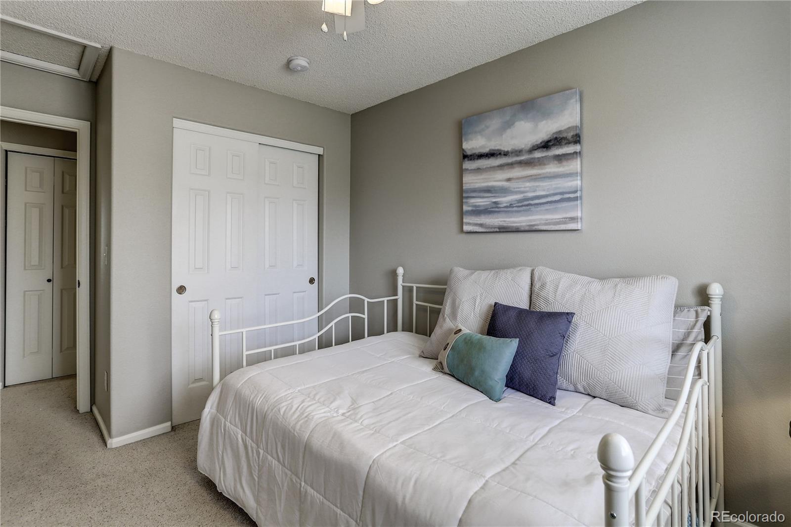 10626 Hyacinth Court Highlands Ranch, CO 80129 - Photo 22 of 38 a bedroom with a bed and a painting on the wall