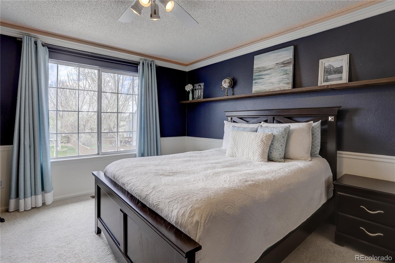 10626 Hyacinth Court Highlands Ranch, CO 80129 - Photo 24 of 38 a bedroom with a bed and a chandelier