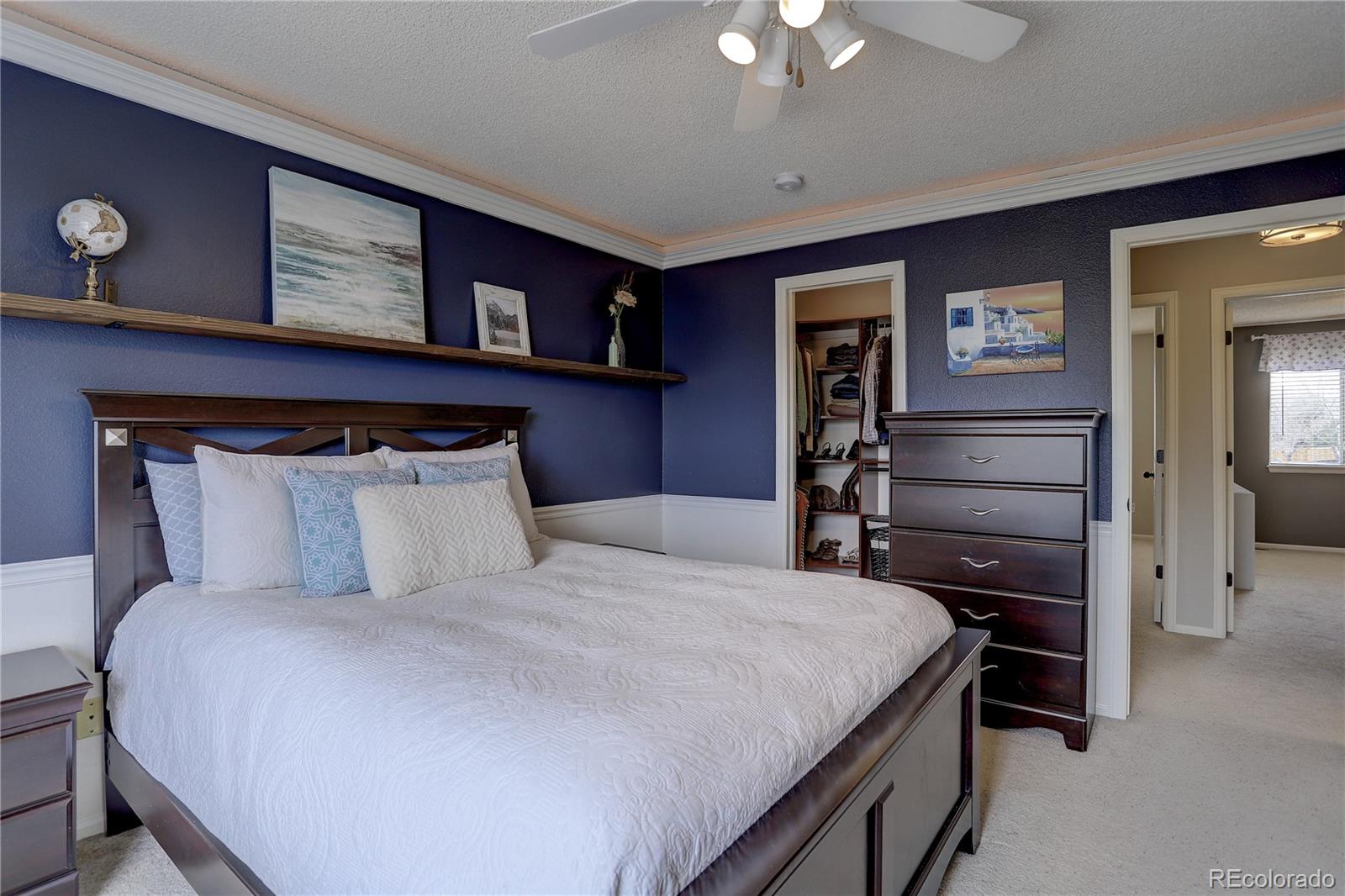 10626 Hyacinth Court Highlands Ranch, CO 80129 - Photo 25 of 38 a bedroom with a bed and a chandelier