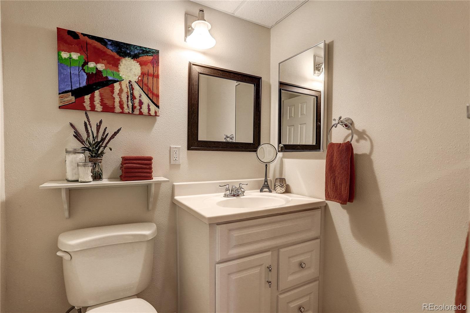 10626 Hyacinth Court Highlands Ranch, CO 80129 - Photo 30 of 38 a bathroom with a toilet sink and mirror