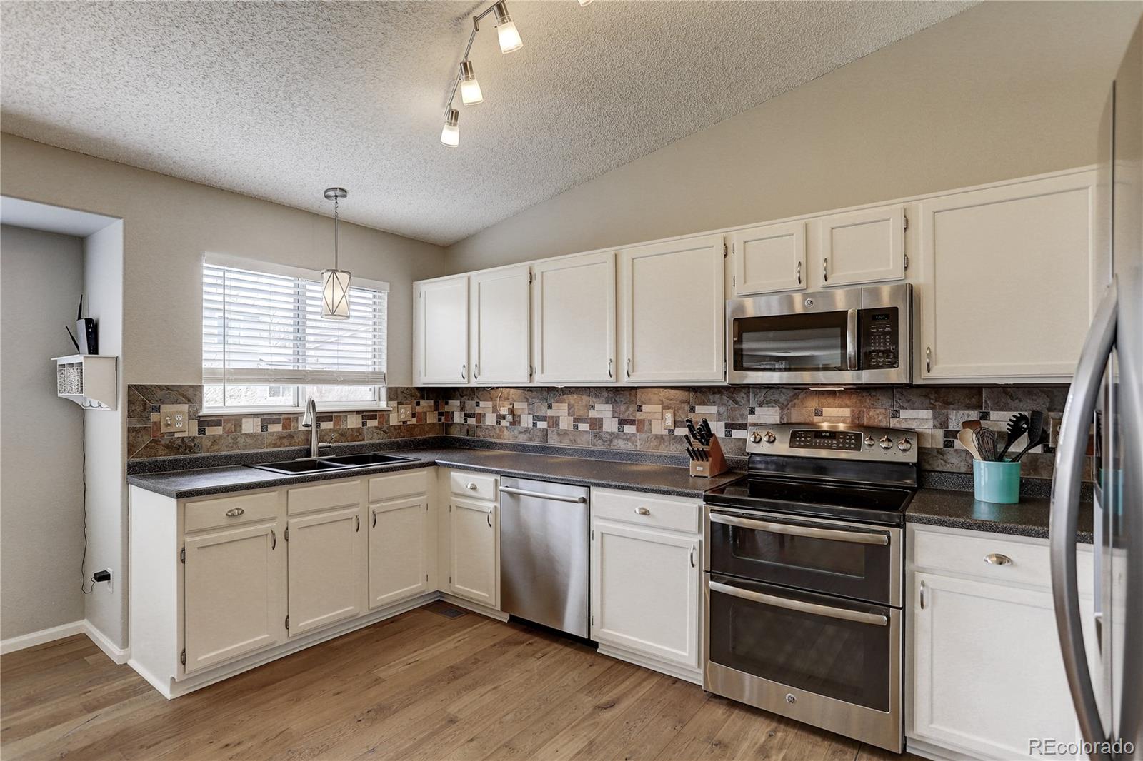 10626 Hyacinth Court Highlands Ranch, CO 80129 - Photo 10 of 38 a kitchen with stainless steel appliances granite countertop a sink and cabinets