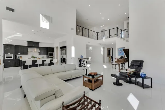 a living room with furniture kitchen view and a chandelier