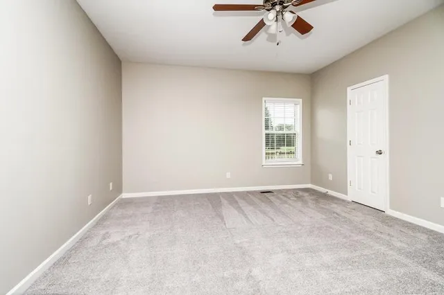 an empty room with a window and a ceiling fan