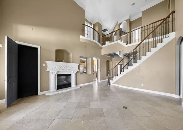 a view of an empty room with a fireplace and a window
