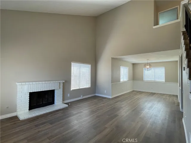 an empty room with wooden floor and fireplace