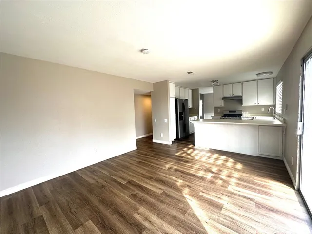 a view of a kitchen with wooden floor and a sink