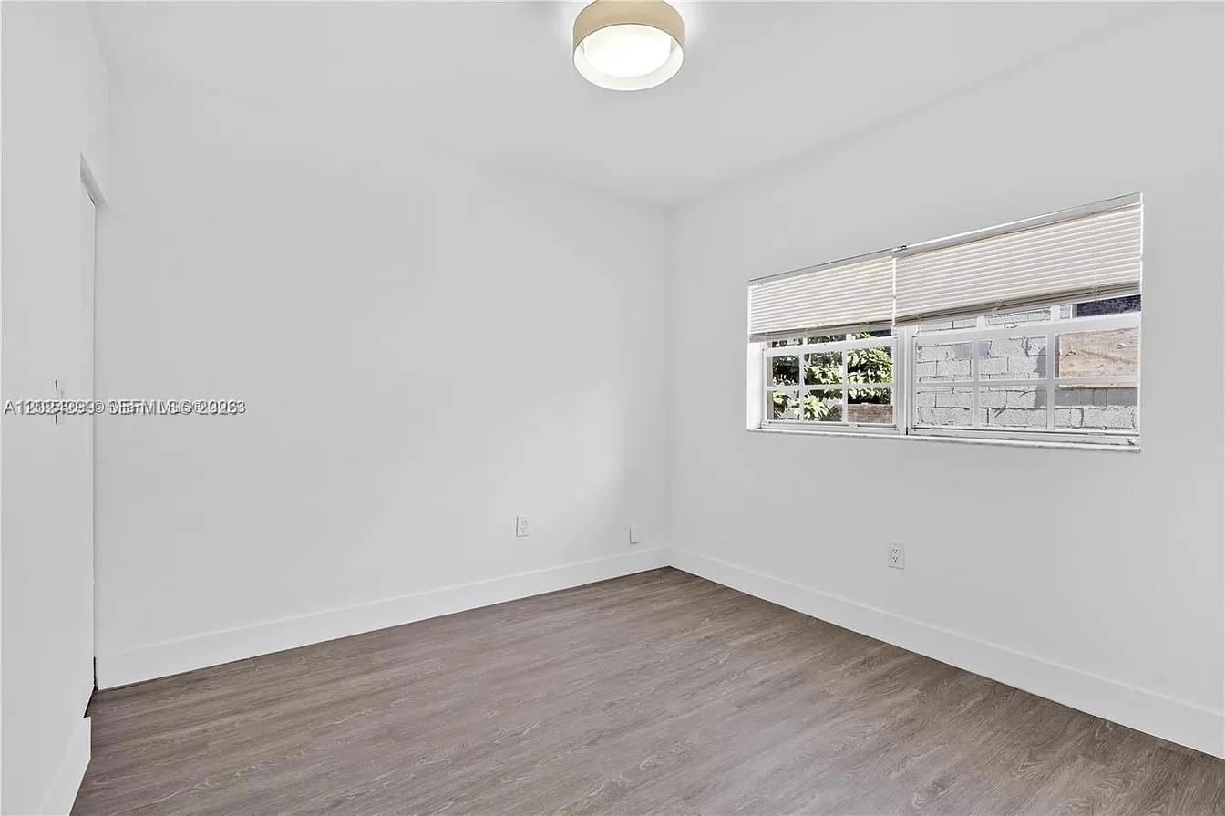 1351 Southwest 4th Street, Unit 8 Miami, FL 33135 - Photo 8 of 11 an empty room with wooden floor and windows