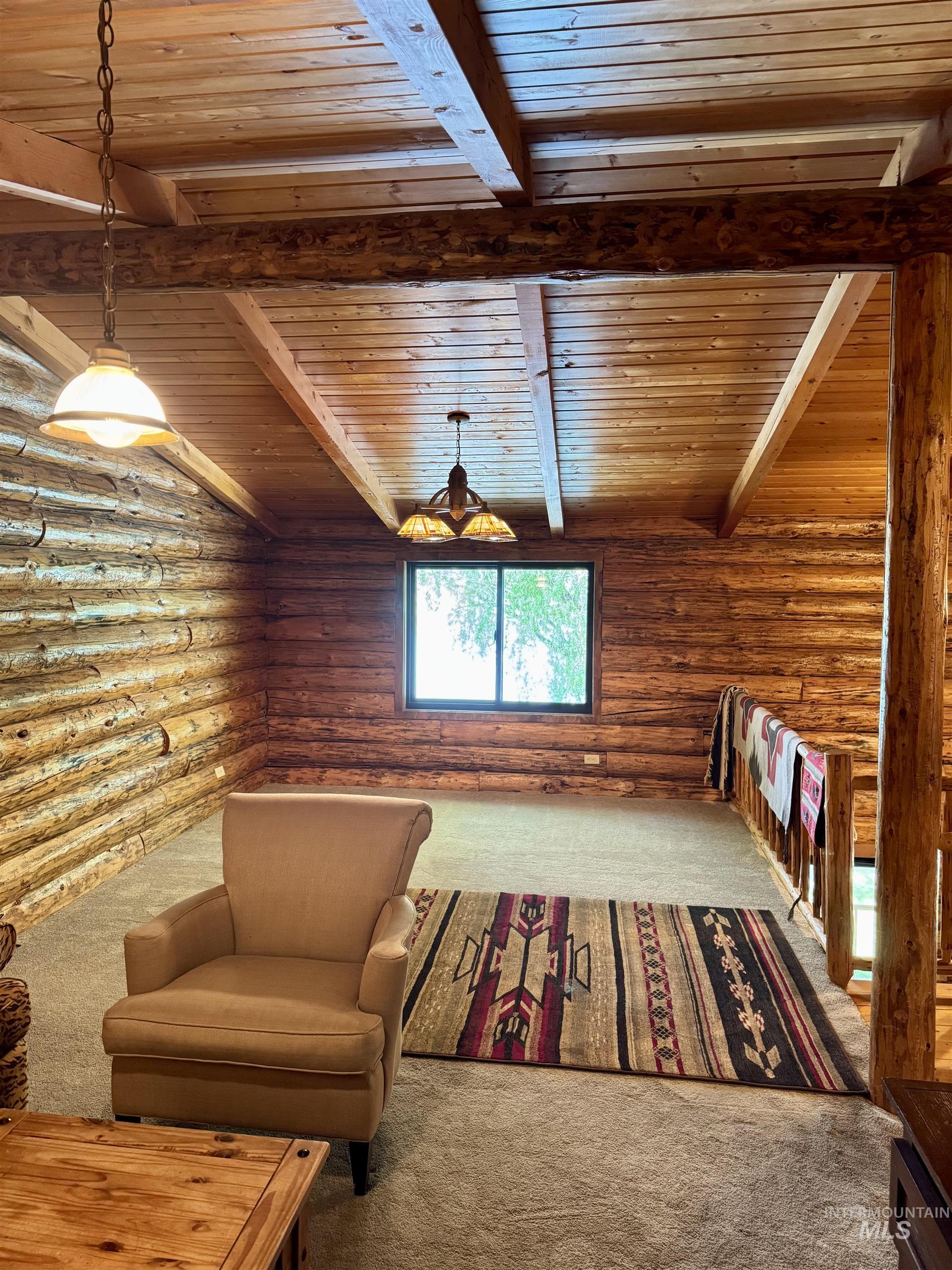 62 Bell Rapids Road Hagerman, ID 83332 - Photo 21 of 34 Expansive log cabin interior featuring natural wood walls and a vaulted ceiling with exposed wood beams