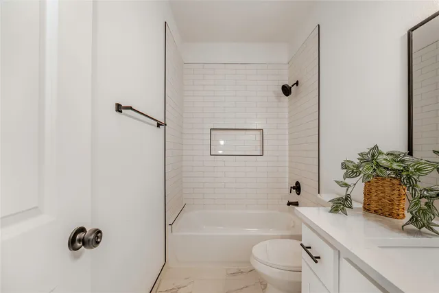 a bathroom with a sink a toilet a tub and shower