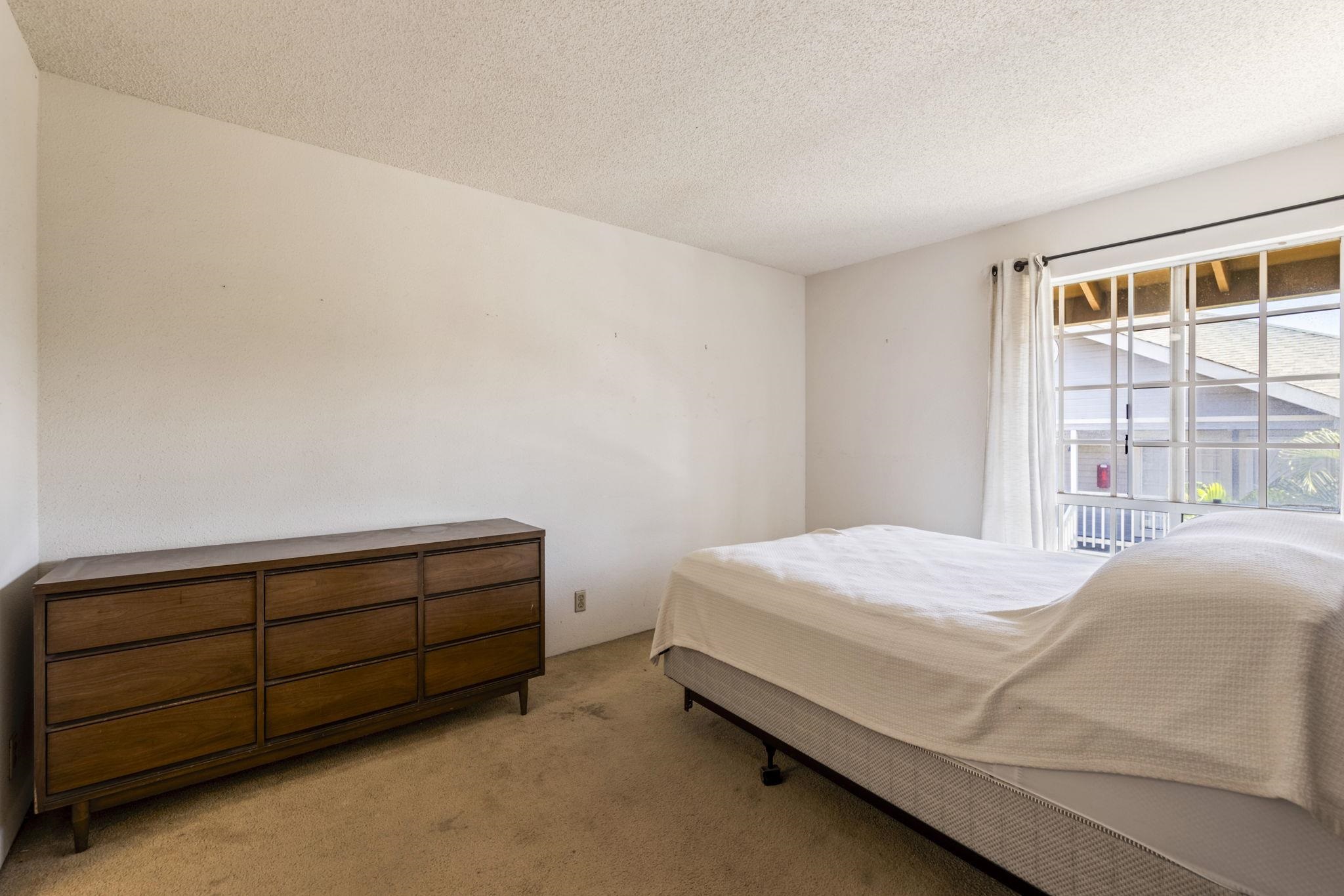 140 Uwapo Road, Unit 18203 Kihei, HI 96753 - Photo 16 of 40 a bedroom with a bed and a window