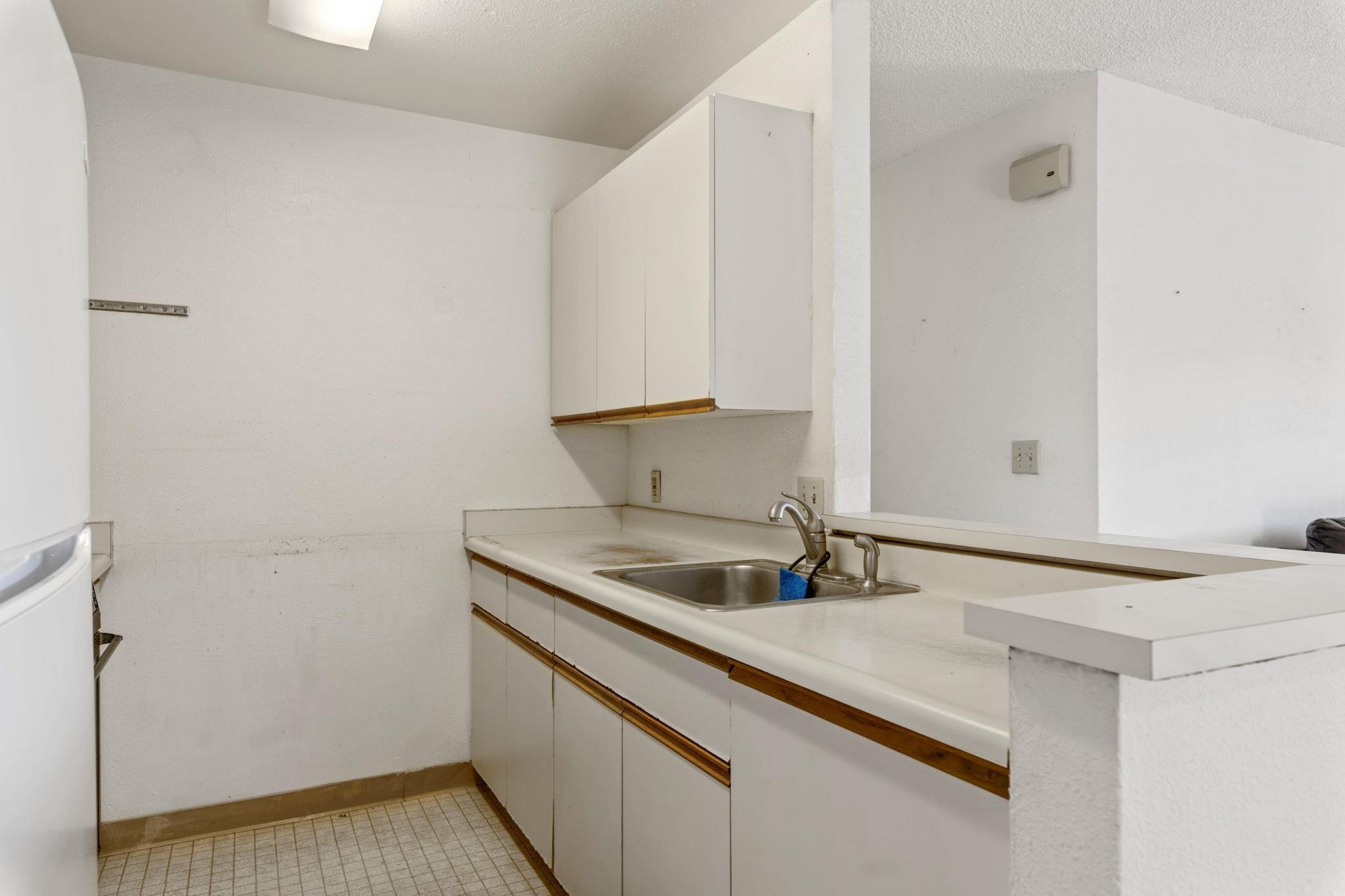 140 Uwapo Road, Unit 18203 Kihei, HI 96753 - Photo 8 of 40 a kitchen with a sink and a refrigerator
