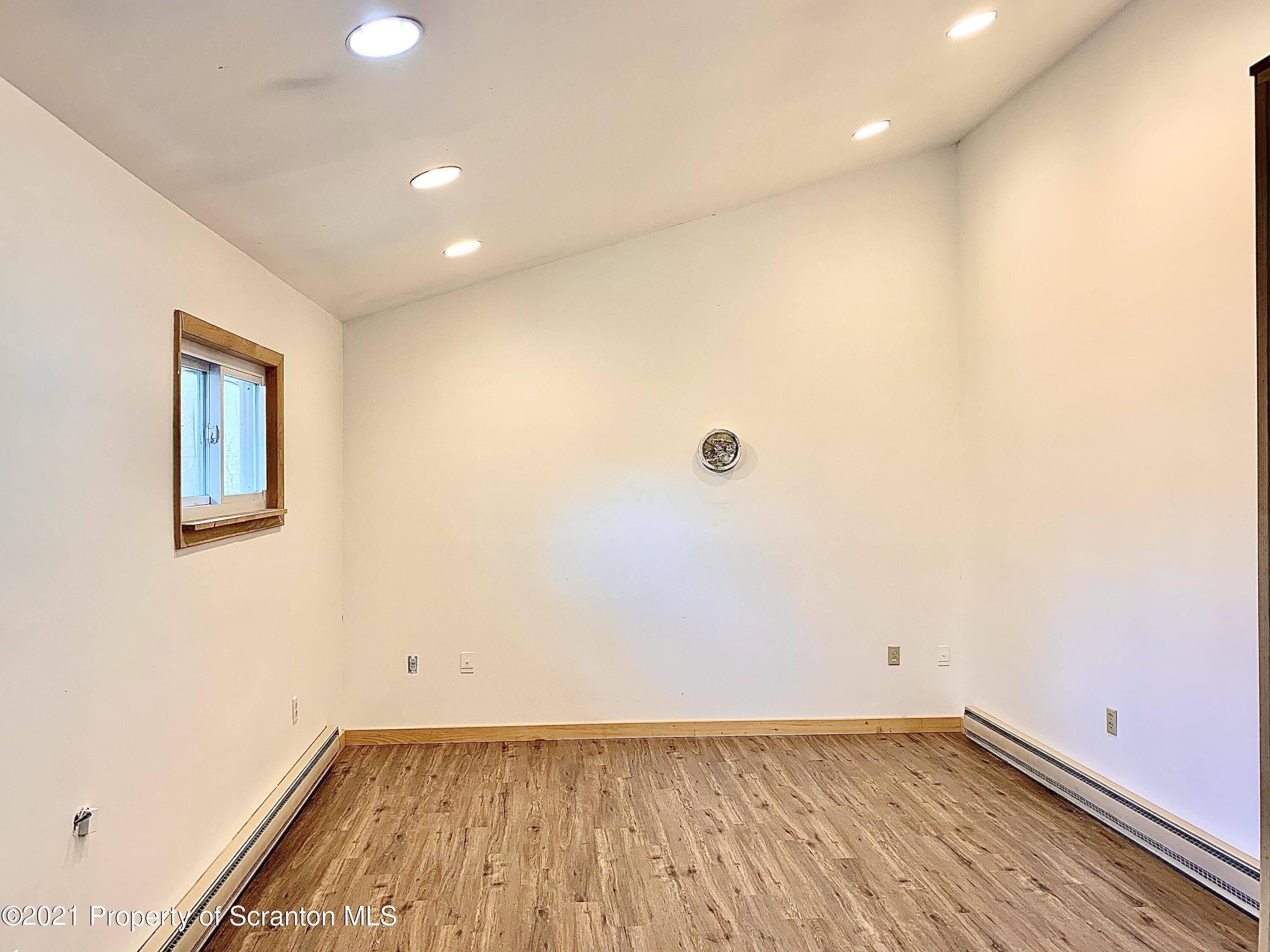 3886 Button Road Hop Bottom, PA 18824 - Photo 11 of 29 an empty room with wooden floor and windows