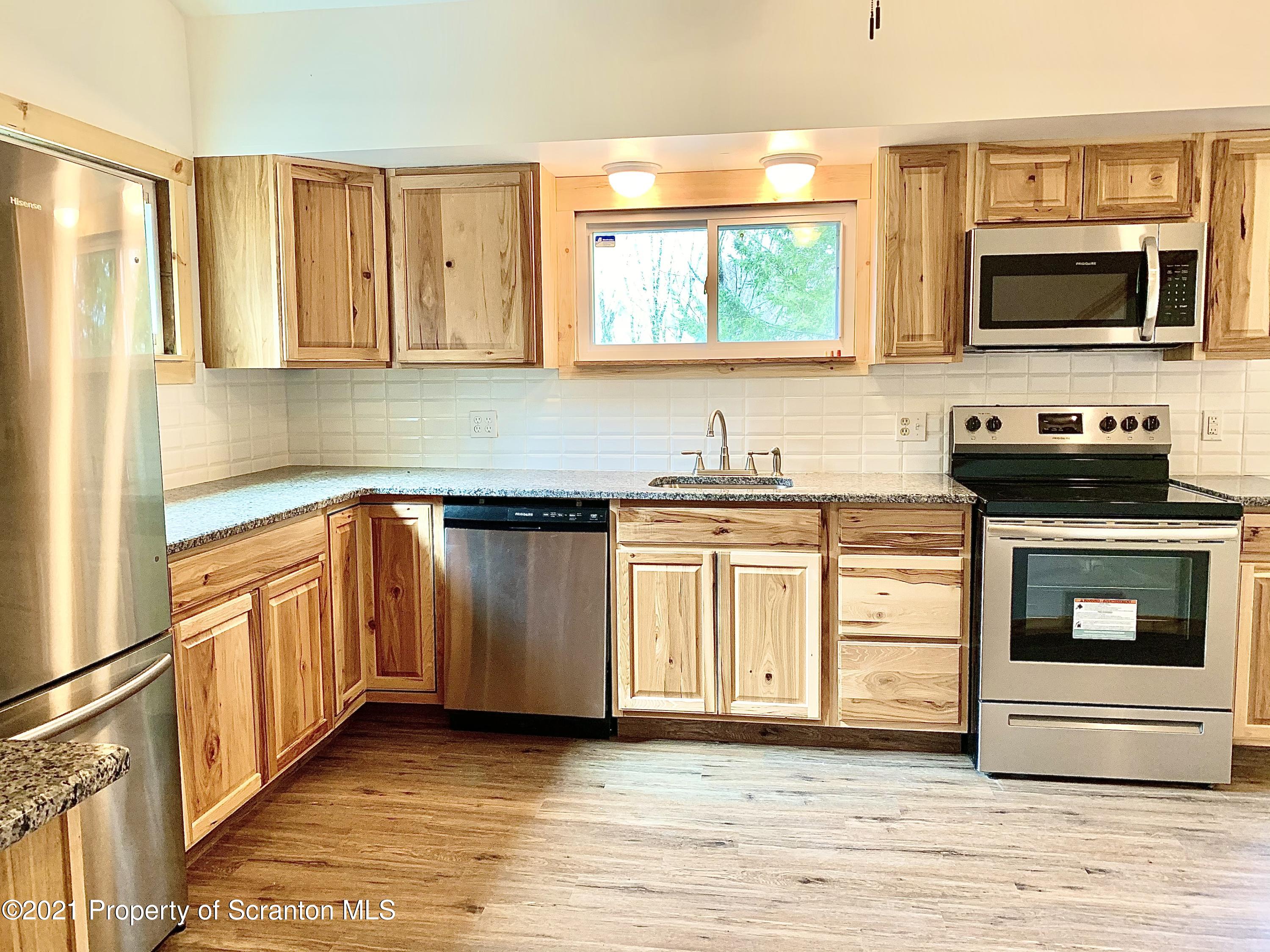 3886 Button Road Hop Bottom, PA 18824 - Photo 8 of 29 a kitchen with stainless steel appliances a stove sink microwave and cabinets