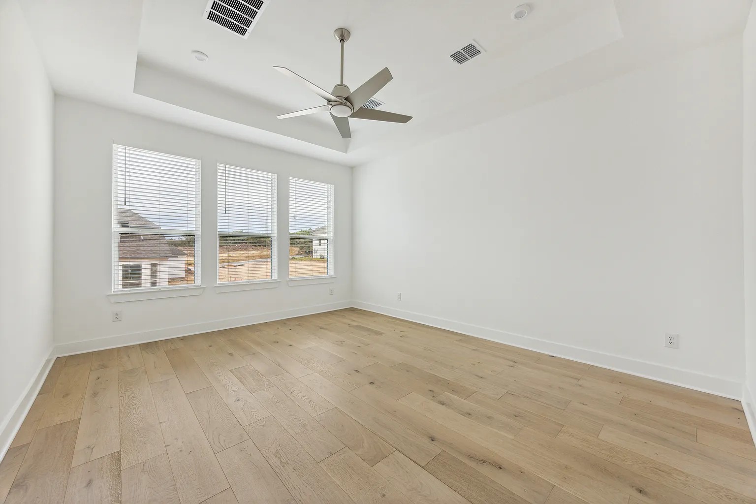 1909 Varese Path Leander, TX 78641 - Photo 18 of 40 Plenty of natural light fills this spacious room, featuring elegant hardwood flooring and a functional ceiling fan.