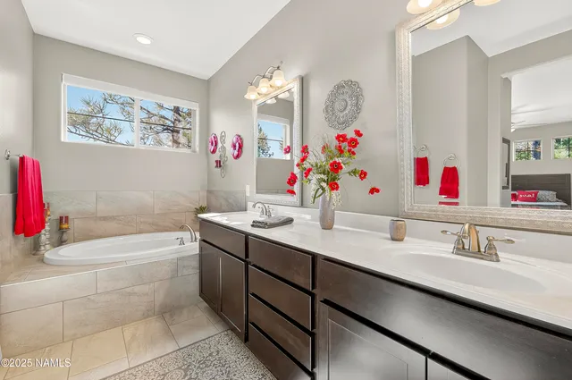 a bathroom with a sink vanity tub and a mirror