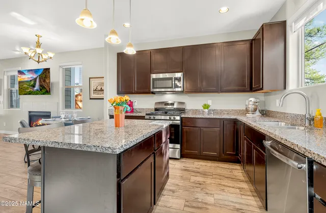 a kitchen with stainless steel appliances granite countertop a sink stove and refrigerator