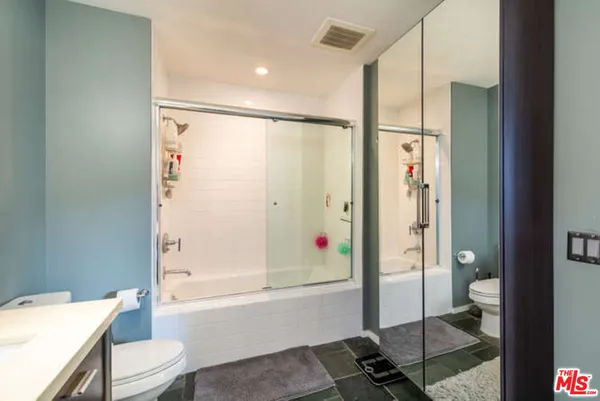 a bathroom with a shower a toilet and a sink