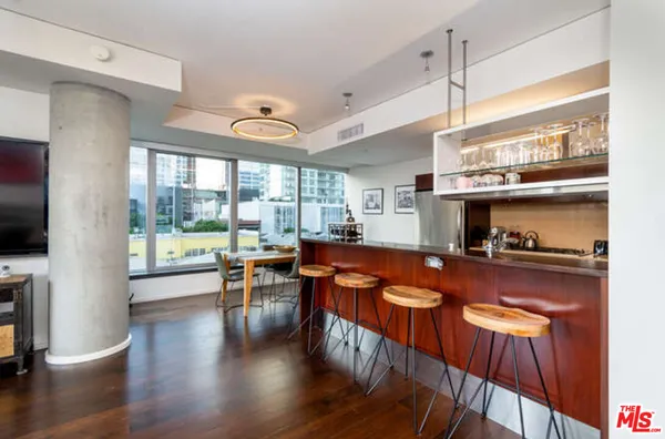 a kitchen with stainless steel appliances granite countertop a stove a refrigerator a oven a dining table and chairs with wooden floor