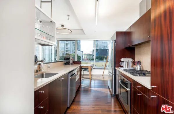 a kitchen with stainless steel appliances granite countertop a sink a stove and a wooden floors