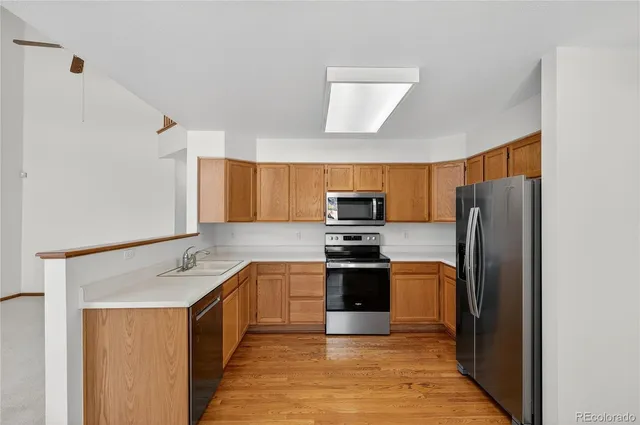 a kitchen with stainless steel appliances granite countertop a refrigerator stove and sink