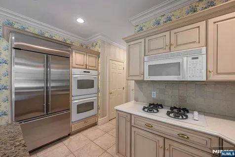 a kitchen with white cabinets and white appliances