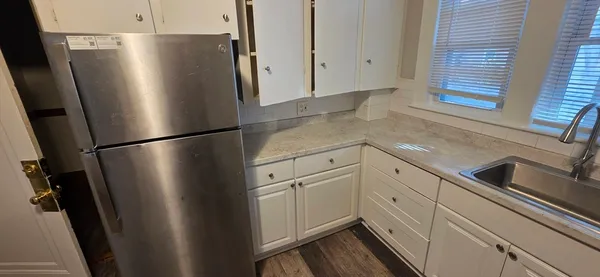 a kitchen with stainless steel appliances a refrigerator a sink and cabinets