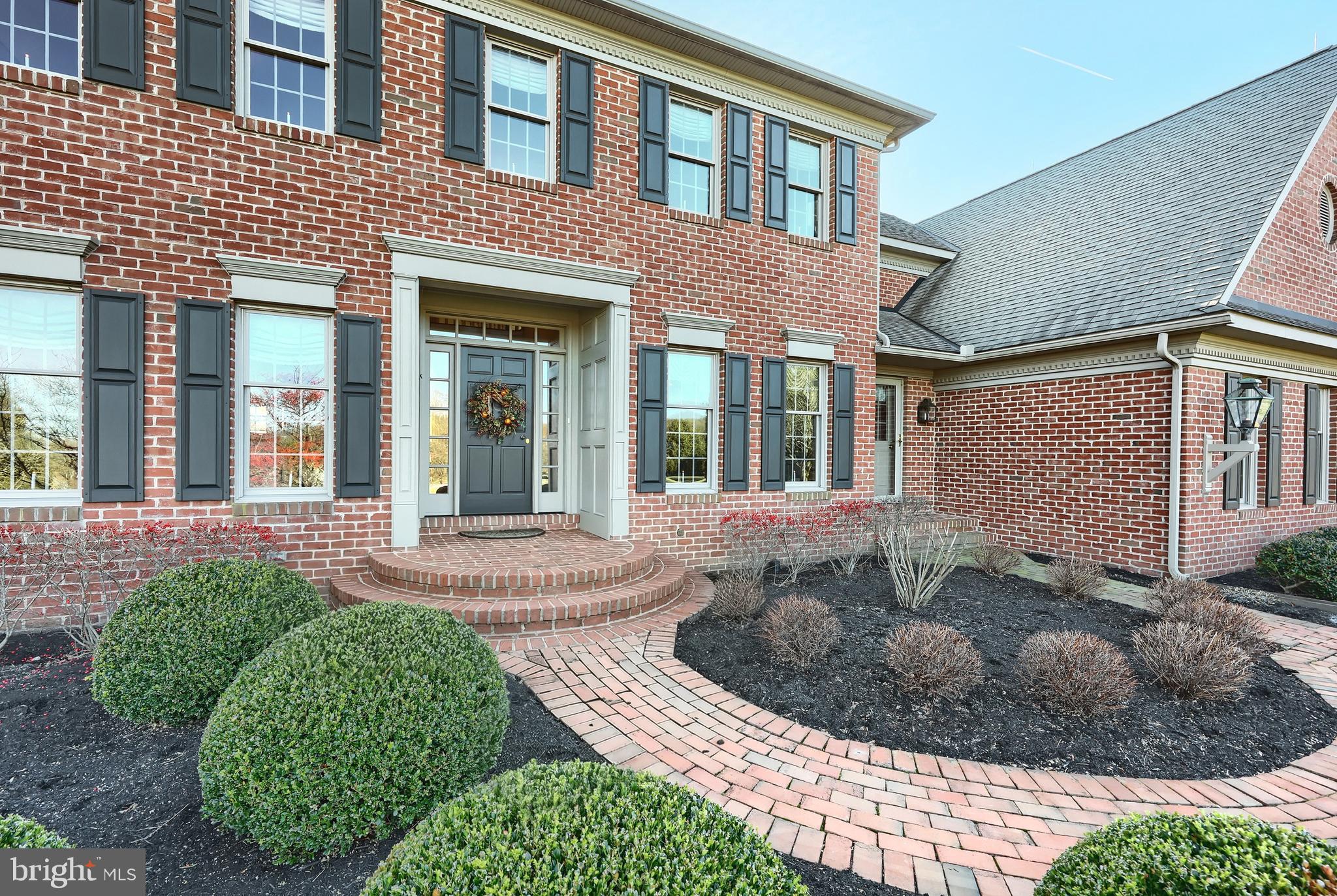 245 Orchard Drive Hanover, PA 17331 - Photo 5 of 78 a view of a brick house with plants and large tree