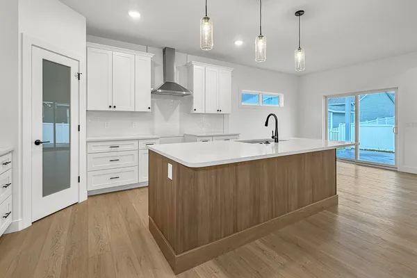 a kitchen with stainless steel appliances granite countertop a sink a stove and a wooden floors