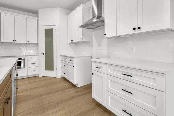 a kitchen with white cabinets and white appliances