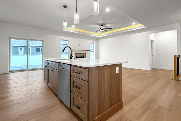 a kitchen with stainless steel appliances granite countertop a sink a stove and a wooden floors
