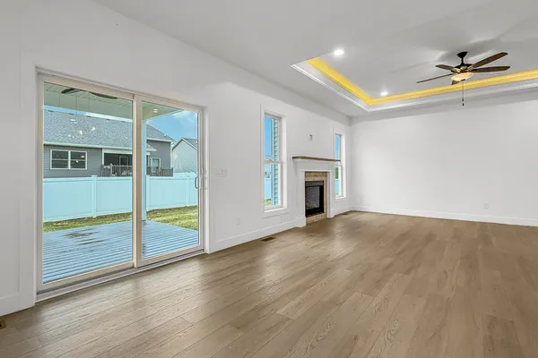 an empty room with wooden floor and a fireplace