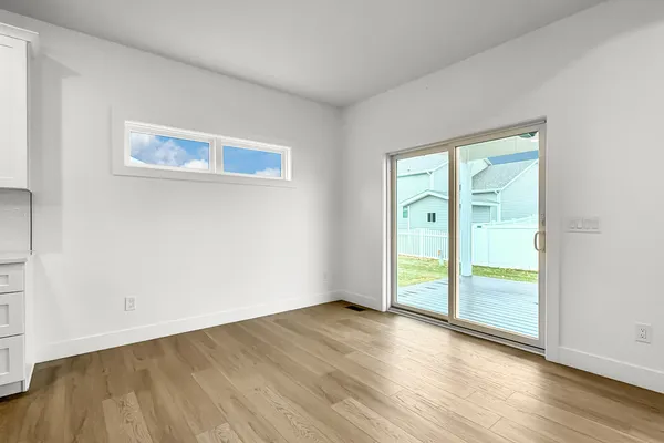 an empty room with wooden floor and door