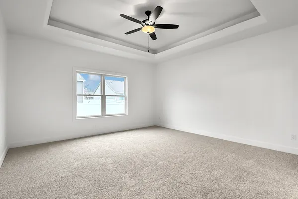 an empty room with a window and a ceiling fan