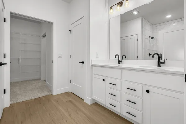 a bathroom with double vanity sink and mirror