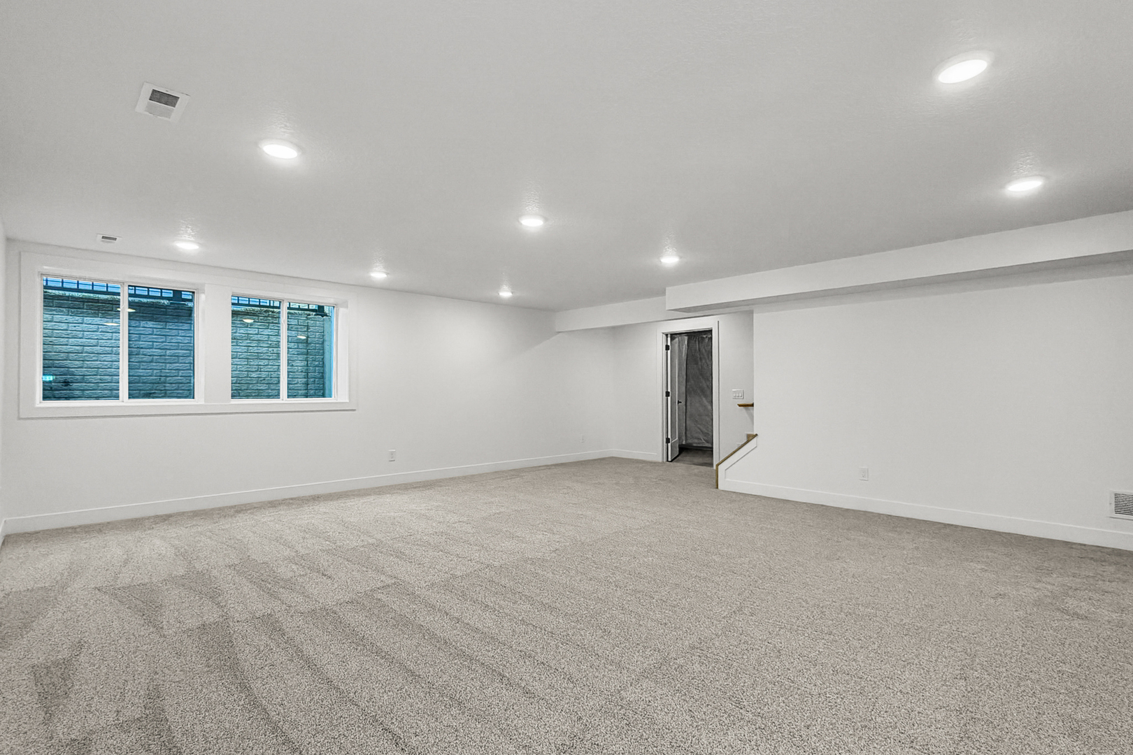 606 Kevin Road Blue Grass, IA 52726 - Photo 10 of 33 an empty room with wooden floor and windows