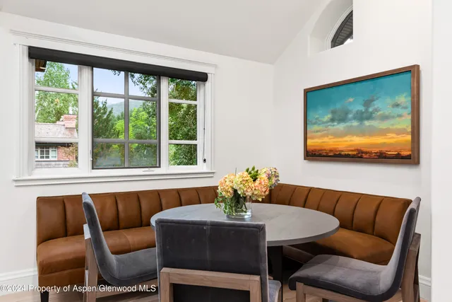 a dining room with furniture and a large window