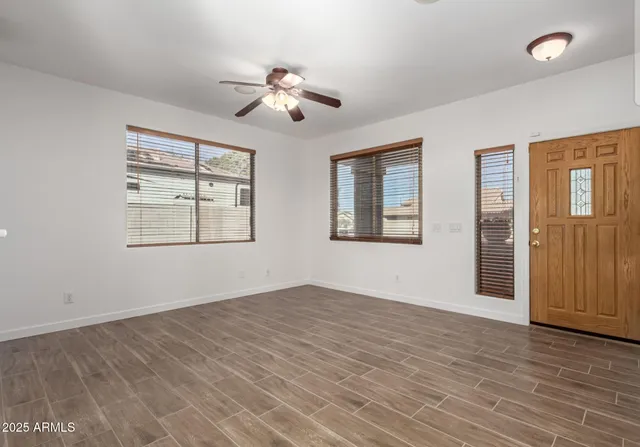 a view of a livingroom with a fireplace a window and wooden floor