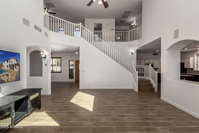 a view of an empty room with window and wooden floor