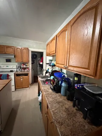 a kitchen with a sink appliances cabinets and a window