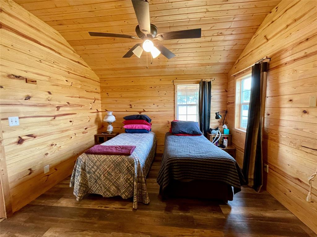 214 Cedar Creek Park Road Whitney, TX 76692 - Photo 22 of 32 a bedroom with a bed wooden floor and window