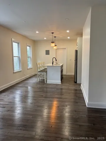 a view of a living room and kitchen with furniture wooden floor and window
