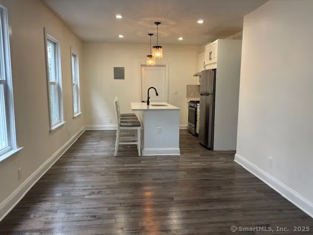 a view of a kitchen with wooden floor and a window