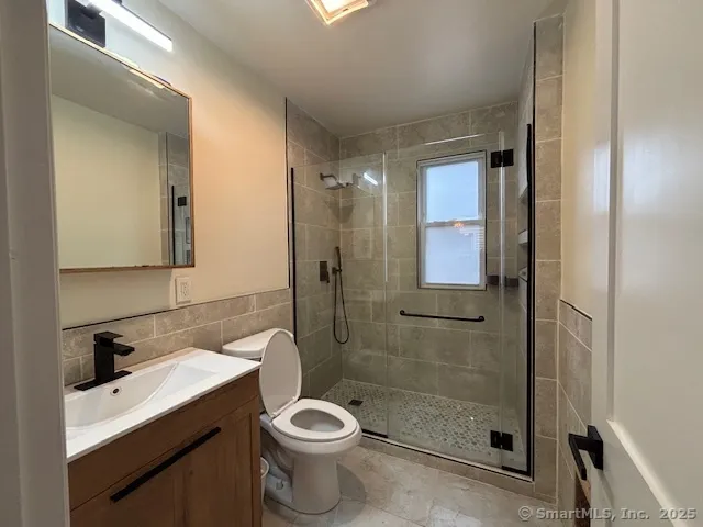 a bathroom with a shower a sink a toilet and mirror